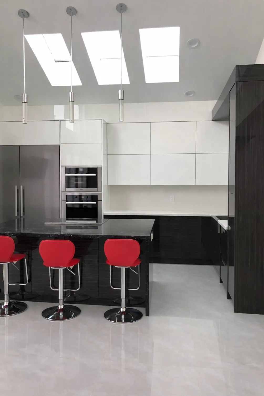 High-Gloss Black & White Kitchen — A modern kitchen featuring white and black premium high-gloss panels with subtle white details to match the deep dark stonework.